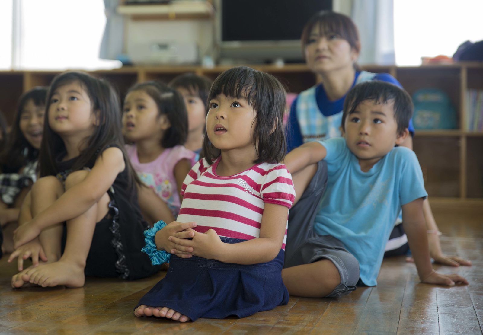 Children sitting together in a lesson, listening to their teacher